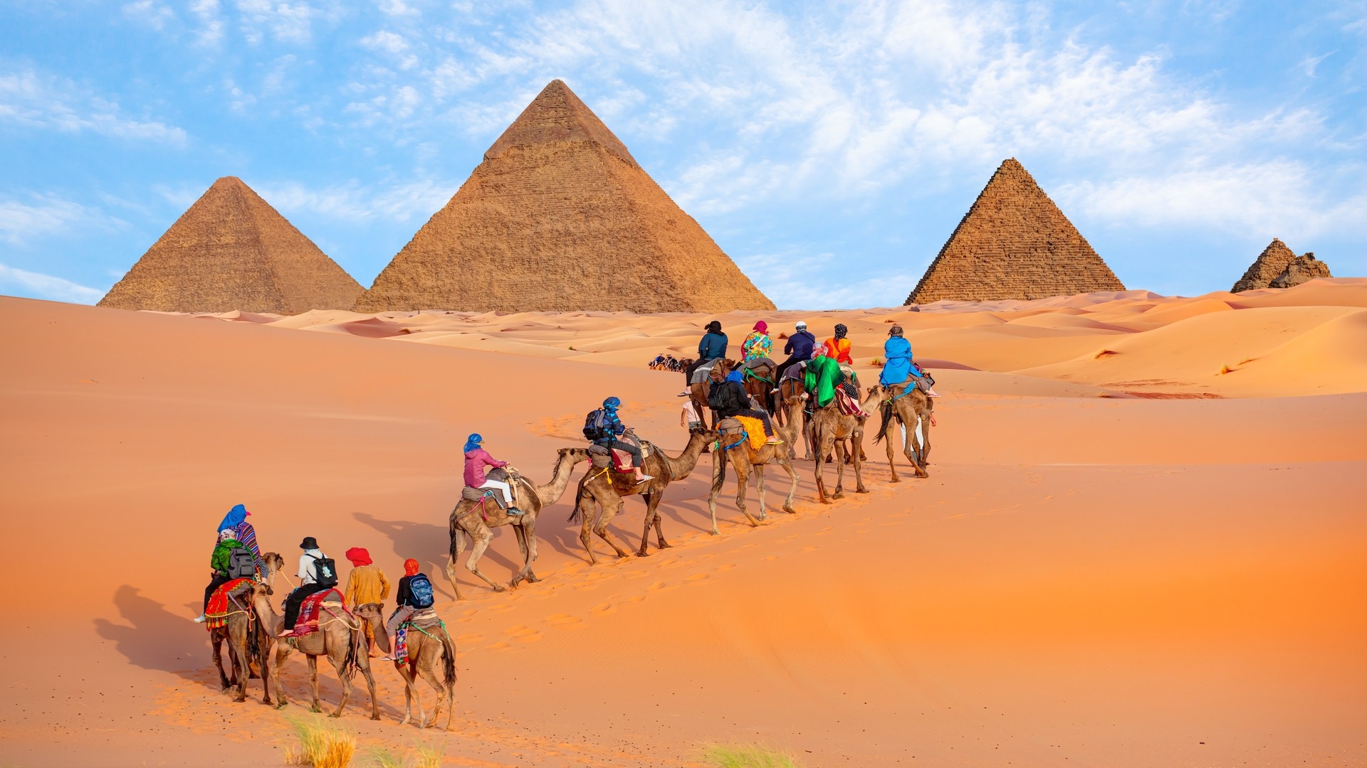 Группа туристов на верблюдах у пирамид Гизы.